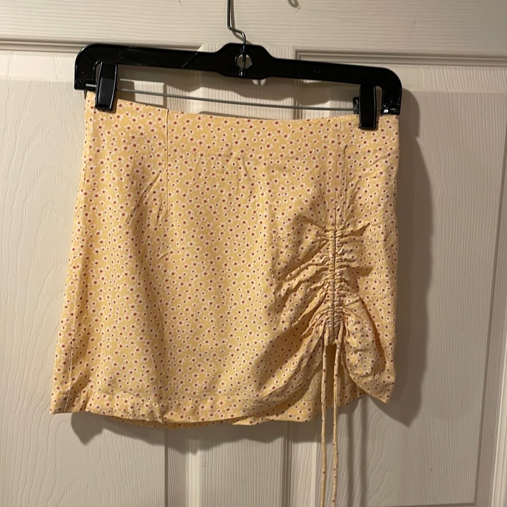 XS mini skirt.  Yellow with orange flowers and shirred on the left side.